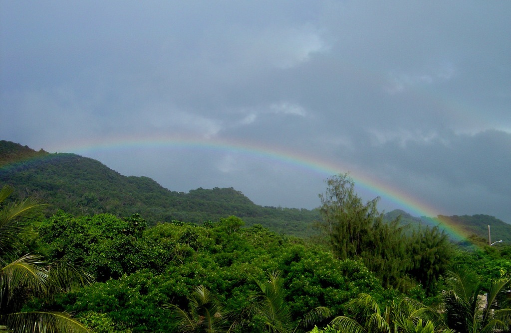 A rainbow graces the jungle foliage of the Guam mountains. Mariana Islands, Guam.