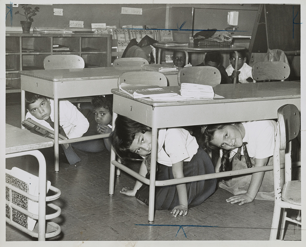 P.S. 58 - Carroll & Smith Sts. Bklyn. hold a 'take cover' drill practice. Here youngsters crawl under their desks / / photo by Walter Albertin.