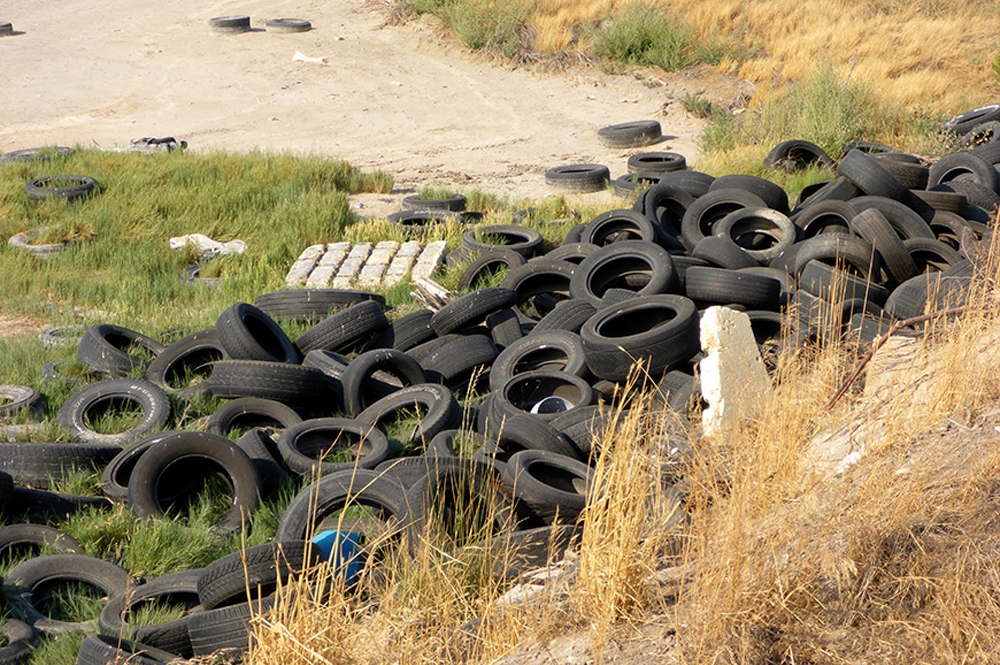 In January 2018, Tina started receiving complaints about an illegal tire dump at Lee Kay Ponds at approximately 6600 West 1300 South in Salt Lake City. Visitors to the pond — a popular bird watching spot — reported a large number of old tires dumped along the shores. Mixed in with the tires were mattresses, construction material, and an RV. [Credit: Utah Department of Environmental Quality - Waste Management and Radiation Control]